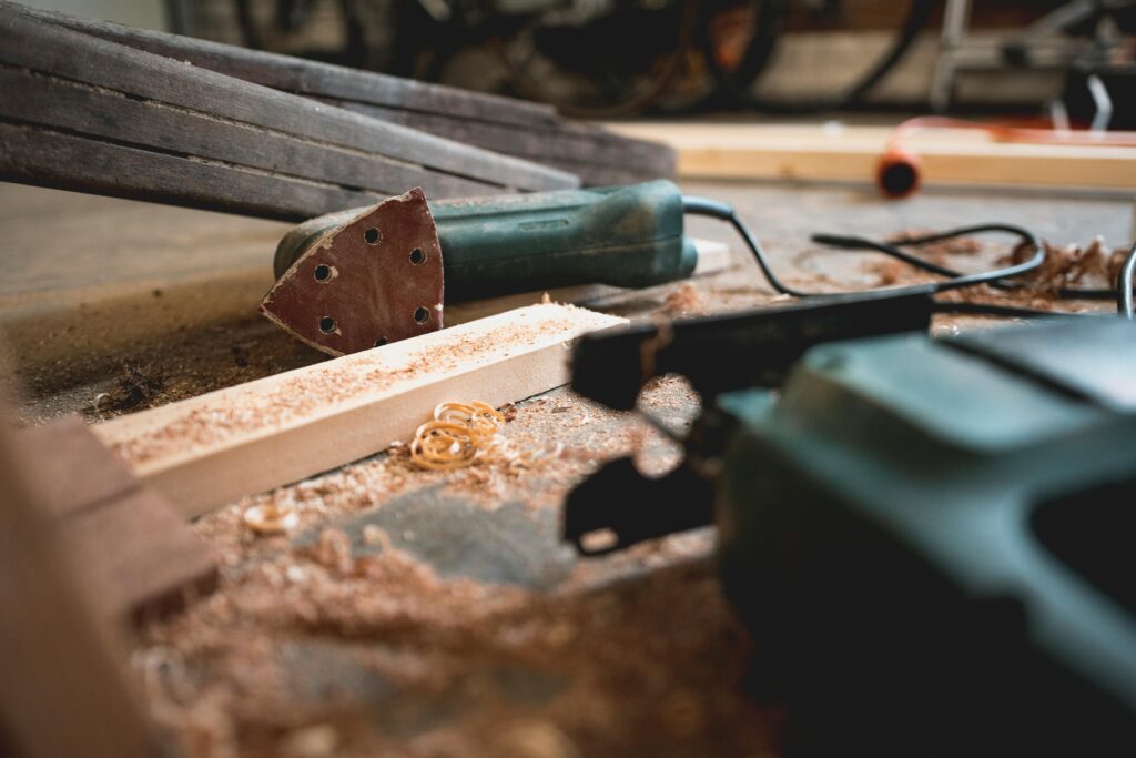 carpentry tools on the floor with woodchips and dust around them